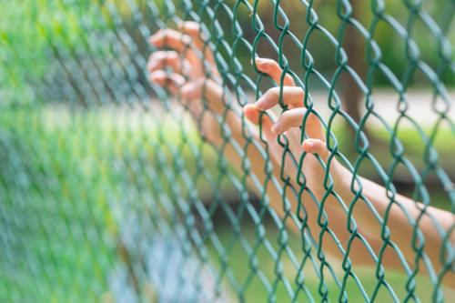 Child behind fence